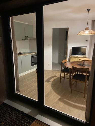 a view of a kitchen and a table through a window at Duplex Le Hêtre in Breitenbach-Haut-Rhin