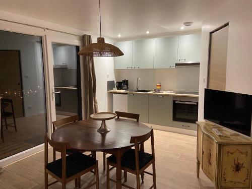 a kitchen with a wooden table and a dining room at Duplex Le Hêtre in Breitenbach-Haut-Rhin