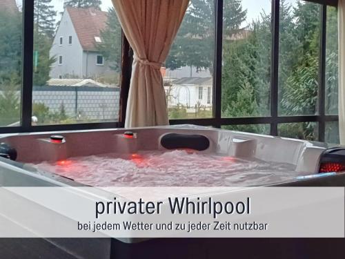 a bath tub filled with water in front of a window at Germersheimer Rhein-Idylle Sauna, Whirlpool in Germersheim