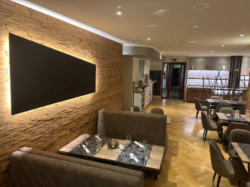 a restaurant with a large television on a wall at Hotel Haus am Ahorn in Schöneck