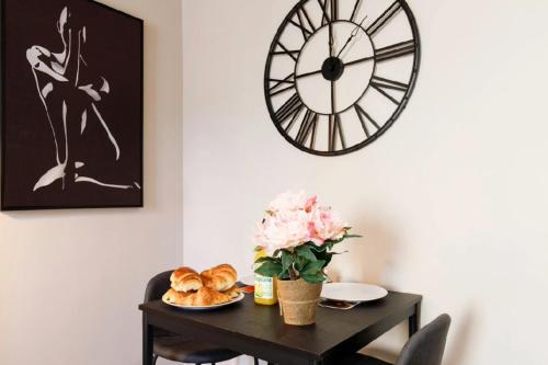 une table avec des pâtisseries et une horloge murale dans l'établissement Studio N , Hypercentre à 2 minutes du Palais des congrès, à Cannes