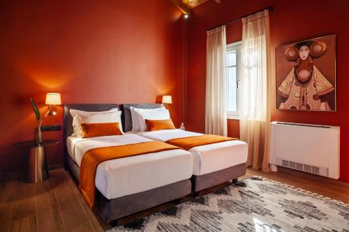 a bedroom with a large bed with orange walls at Archontiko Parnassus Dadi in Amfiklia