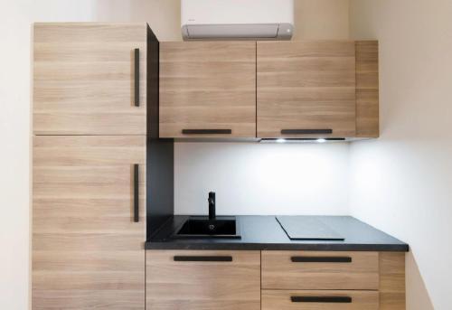 une cuisine avec des armoires en bois et un évier dans l'établissement Studio N , Hypercentre à 2 minutes du Palais des congrès, à Cannes