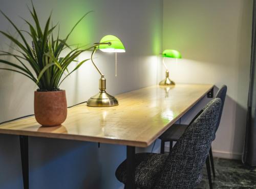 a table with two lamps and a potted plant on it at Apartment 105 sq.m. near center in Patra