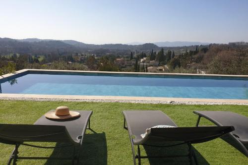 - un chapeau assis sur deux chaises à côté de la piscine dans l'établissement Modern House with Pool and Beautiful Terrace Sea View - BENAKEY, à Opio