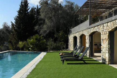 - deux chaises assises à côté de la piscine dans l'établissement Modern House with Pool and Beautiful Terrace Sea View - BENAKEY, à Opio