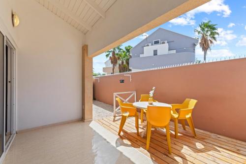 a dining room with a table and chairs on a balcony at Villa 449 Piscadera in Sint Michiel