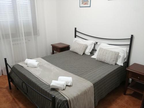 Un dormitorio con una cama grande con toallas. en A Casa di Gino, en Desenzano del Garda
