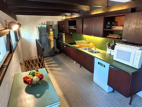 - une cuisine avec un bol de fruits sur une table dans l'établissement Villa spacieuse à 6 minutes des plages et marché, idéale pour familles et amis, WiFi inclus - FR-1-736-35, à Lège-Cap-Ferret