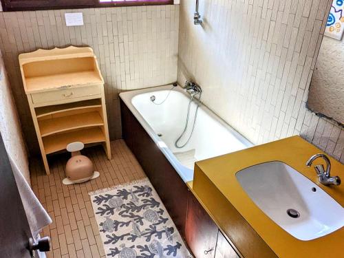 une petite salle de bain avec une baignoire et un lavabo dans l'établissement Villa spacieuse à 6 minutes des plages et marché, idéale pour familles et amis, WiFi inclus - FR-1-736-35, à Lège-Cap-Ferret