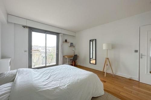 une chambre blanche avec un lit et une grande fenêtre dans l'établissement Flexliving - room - Ternes, à Paris