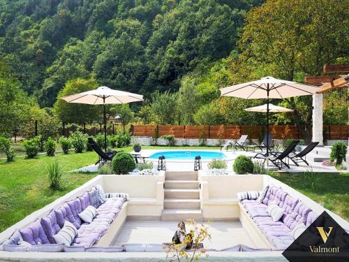 a backyard with purple couches and a pool at Valmont Luxury Chalet in Glozhene