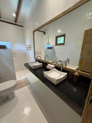 a bathroom with two sinks and a large mirror at TRANCOSO - Casa Vista do Espelho in Porto Seguro