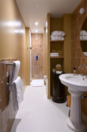 a bathroom with a sink and a toilet and a shower at Hôtel les Prés in Saint-Hilaire-le-Châtel
