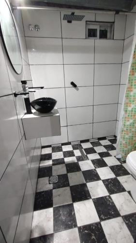 a bathroom with a sink and a checkered floor at Mile y Luci in San Clemente del Tuyú