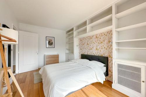 a white bedroom with a bed and a fireplace at Flexliving - room - Ternes in Paris