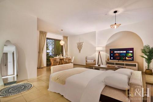 a bedroom with a large bed and a television at Stunning views of Dubai Sea, Dubai Eye & JBRWalk in Dubai