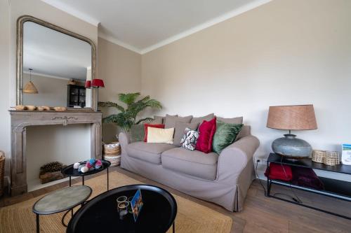 un salon avec un canapé et un miroir dans l'établissement La Mavéria - Beautiful T3 close to the lake, à Annecy