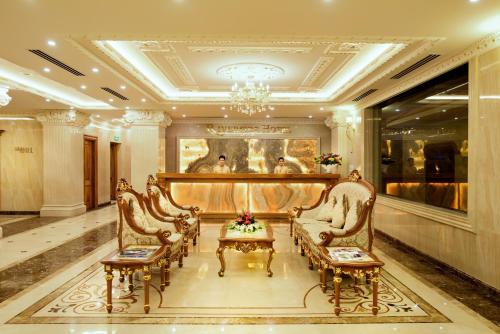 a lobby with chairs and a table and a chandelier at Riverside Hotel Quang Binh in Dong Hoi