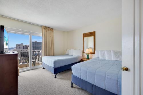 a hotel room with two beds and a balcony at Oceanfront Oasis 1003 in Abbeyville