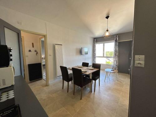 un salon avec une table et des chaises de salle à manger dans l'établissement Bel appartement 2 pièces à Saint-Jean-de-Monts, à 50m de la plage, avec parking privé - FR-1-224C-544, à Saint-Jean-de-Monts
