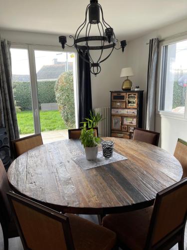 une salle à manger avec une table et des chaises en bois dans l'établissement Grande maison à 200m de la plage, à Plouguerneau