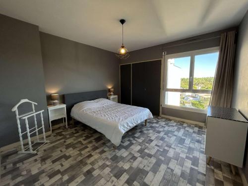 une chambre avec un lit et une grande fenêtre dans l'établissement Bel appartement 2 pièces à Saint-Jean-de-Monts, à 50m de la plage, avec parking privé - FR-1-224C-544, à Saint-Jean-de-Monts