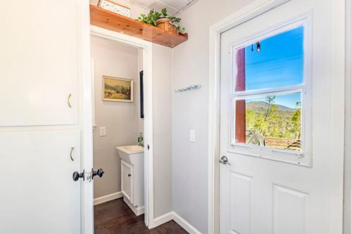 a bathroom with a white door and a window at Sierra Vista Lookout Lodge for 8 people with Hot tub, deck and trail to waterfalls in North Fork