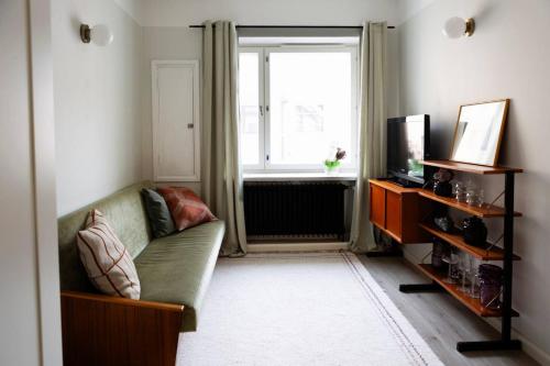a living room with a couch and a window at Vintage Modern Apartment by Sea - Eiranranta in Helsinki