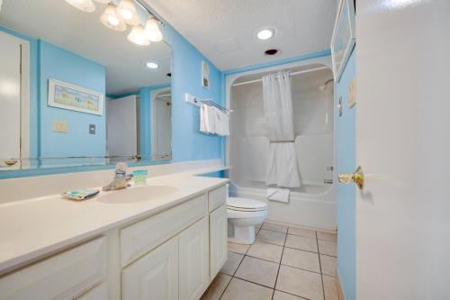a blue bathroom with a sink and a toilet at Oceanfront Oasis 1002 in Abbeyville