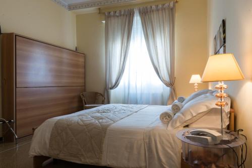 a bedroom with a bed with a telephone and a window at Hotel Eden in Arenzano