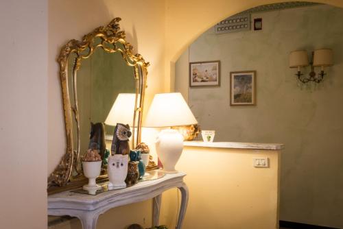 tocador con espejo y lámpara en Hotel Eden, en Arenzano