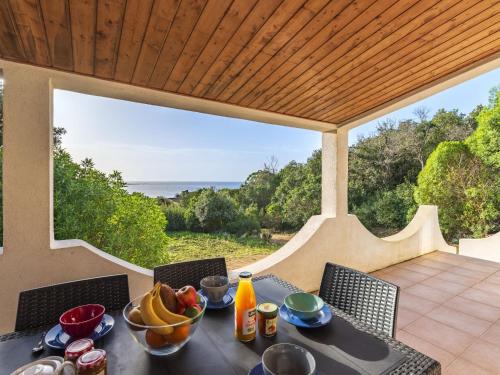 une table avec un bol de fruits sur une terrasse dans l'établissement Holiday Home Villa Bruzzi by Interhome, à Pianottoli-Caldarello