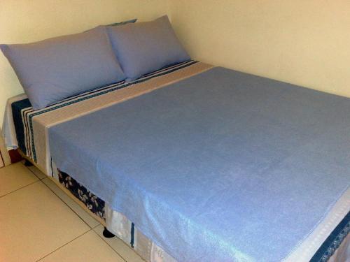 Una cama con sábanas azules y almohadas azules. en Chateau Elysee, en Manila