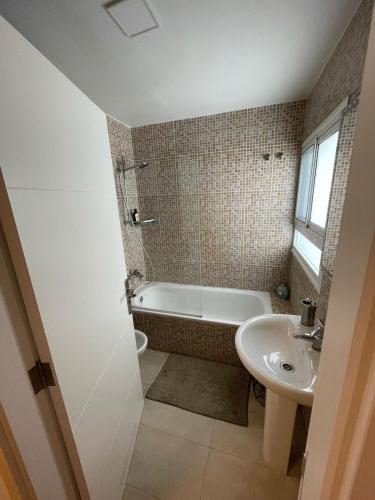 a bathroom with a bath tub and a sink at Casa Mares in Teror