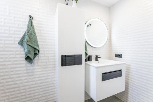 Un baño blanco con lavabo y espejo. en Apartmant Buti Mar, en La Cala de Mijas
