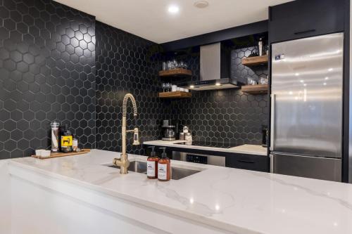 a kitchen with a sink and a refrigerator at Whistler Village 2BR, Sleeps 6, Air Con, Free Parking in Whistler