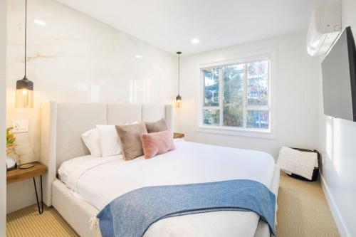 a bedroom with a large white bed with two pillows at Whistler Village 2BR, Sleeps 6, Air Con, Free Parking in Whistler