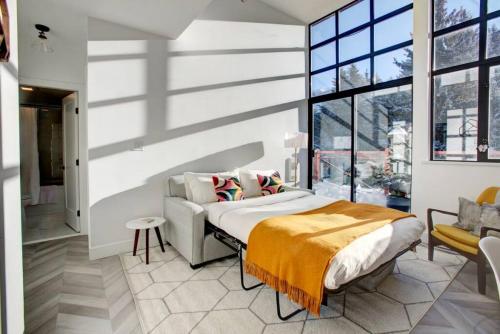 a bedroom with a bed and a large window at Whistler Village 1BR, Sleeps 4, Pool, Hot Tub & Near Shops in Whistler
