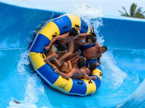 a group of people on a raft in a water slide at Belle Vista - Luxury Canal Front Home near Theme Parks with Pool in Gold Coast