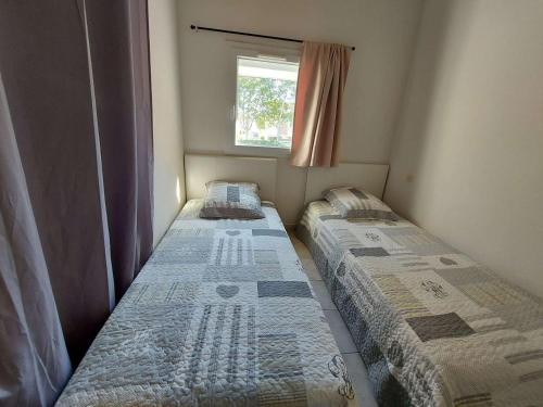 deux lits dans une petite pièce avec une fenêtre dans l'établissement Maison Duplex 3 Pièces, Terrasse, Parking, Plage à Proximité, Idéal Famille - 6 Pers. - FR-1-326-658, à Marseillan