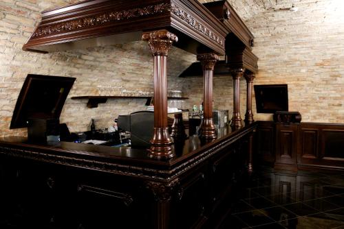 a bar with wooden pillars and a brick wall at Forgách Kastély in Mándok