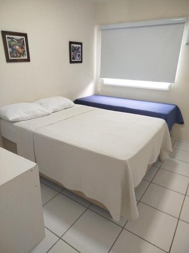 two beds in a room with a window at Porto Real Resort Suites 1 in Mangaratiba