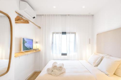 a white bedroom with towels on a bed at Beach front right on the Sand Luxury semi-detached 3 bed Villa in Faro