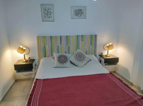 a bedroom with a large white bed with two lamps at Serendipia Santa Ana in Santa Ana