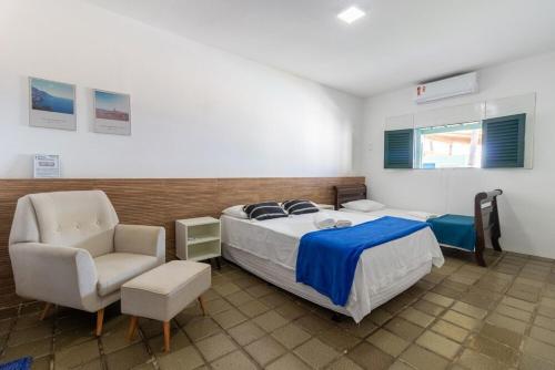 a bedroom with a bed and a chair at Casa beira-mar 25km do aeroporto de Recife in Cabo de Santo Agostinho
