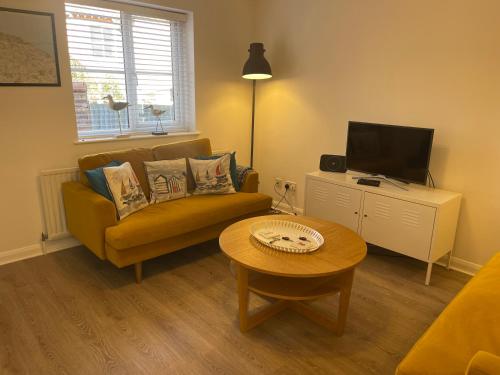 a living room with a couch and a coffee table at Avocet Cottage Sheringham in Sheringham