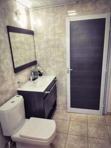 a bathroom with a toilet and a sink and a mirror at Serendipia Santa Ana in Santa Ana