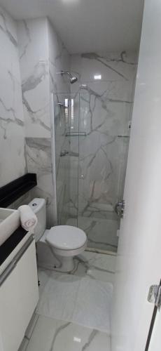 a bathroom with a toilet and a glass shower at AP no Centro, Ao lado de Praça de Poços de Caldas in Poços de Caldas