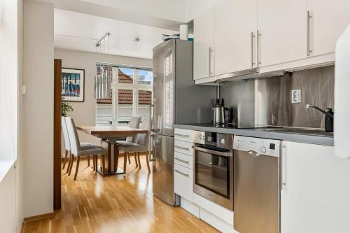 a kitchen with stainless steel appliances and a table at Dinbnb Apartments I Historical Two-Floor Apartment with Rooftop Panorama I 1645 Heritage in Bergen